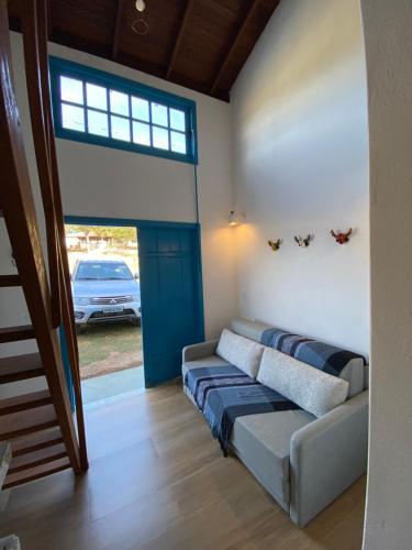 a living room with a couch and a window at Espaço Tropicália in Pirenópolis