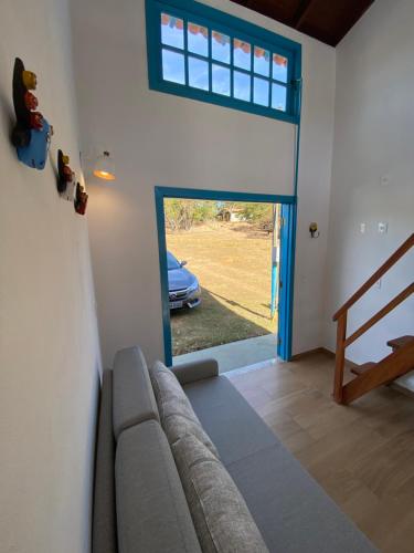 a living room with a couch and a sliding glass door at Espaço Tropicália in Pirenópolis