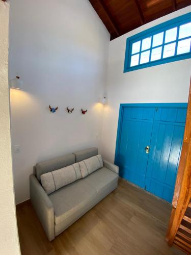 a living room with a couch and blue cabinets at Espaço Tropicália in Pirenópolis