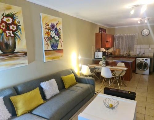 ein Wohnzimmer mit einem Sofa und einer Küche in der Unterkunft Midrand Ninth on Lever Shalom in Midrand