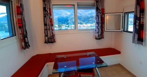 a room with a bench and a table and windows at Traditional house with sea view ''MYLOS'' in Poros