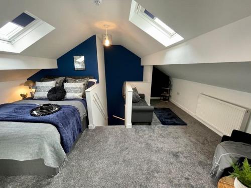 a bedroom with blue walls and a bed and a chair at Boutique 5 bed home on Birdwell Road - Free parking in Attercliffe