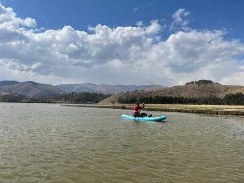 a man sitting on a kayak in the water at CasaHotel Laguna Jauja Airport in Jauja
