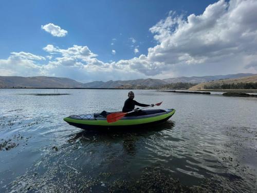 a man in a kayak on a body of water at CasaHotel Laguna Jauja Airport in Jauja