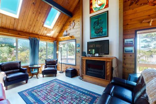 a living room with a fireplace and a tv at Sand and Surf in Rockaway Beach