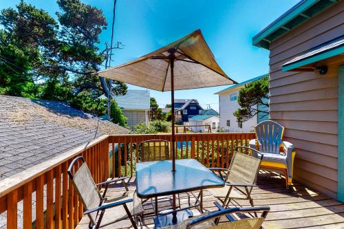a patio with chairs and a table and an umbrella at Sand and Surf in Rockaway Beach