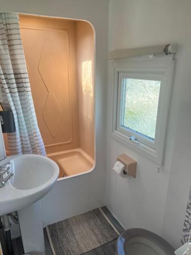 a bathroom with a sink and a window at Castaway retreats 4 C34 in Lincolnshire