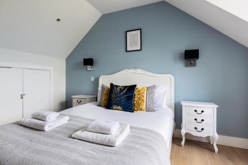 een slaapkamer met een wit bed en een blauwe muur bij The Finchley Apartments in Hendon