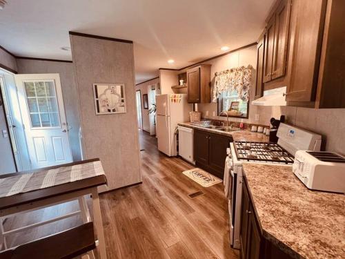 uma cozinha com pisos em madeira e uma bancada em Brand New Mountain Retreat just 20 minutes from Saratoga Springs with private Hot tub. em Middle Grove
