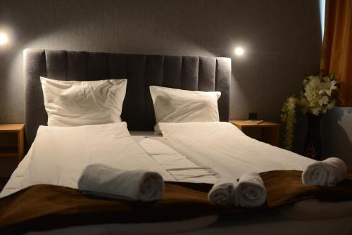 a bedroom with a large bed with white sheets and pillows at Family Hotel Gotse Delchev in Gotse Delchev
