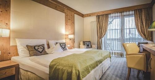 een hotelkamer met een groot bed en een raam bij Taubers Unterwirt Aktiv & Vitalhotel in Feldthurns