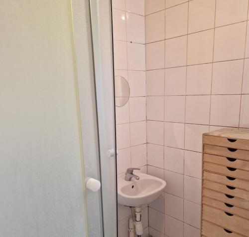 une salle de bain blanche avec un lavabo et une douche dans l'établissement Studio near Paris Métro Robespierre, à Bagnolet