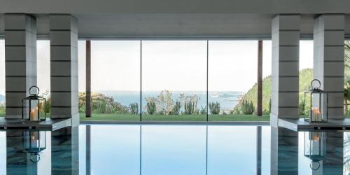 a room with a large window with a view at Lefay Resort & Spa Lago Di Garda in Gargnano