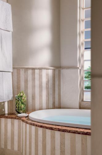 a bath tub in a bathroom with a window at Lefay Resort & Spa Lago Di Garda in Gargnano