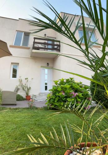 a white house with a balcony and some plants at Sîrbu Orsova in Orşova