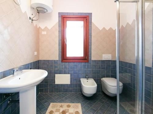 a bathroom with a sink and a toilet at Porto Quadro Villa's in Santa Teresa Gallura