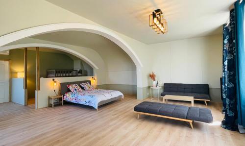 a bedroom with a bed and a couch in a room at La Bastide Champenoise - Chambres d'hôtes in Villers-Allerand