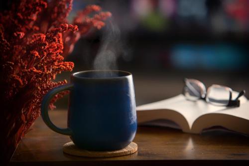 eine blaue Kaffeetasse und ein Buch auf dem Tisch in der Unterkunft Stylish 'New York Loft' 2 Bed Apartment in Bradford