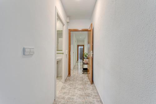 a hallway with a white wall and a hallway with a bathroom at HOSTAL BEDMATES in Barcelona