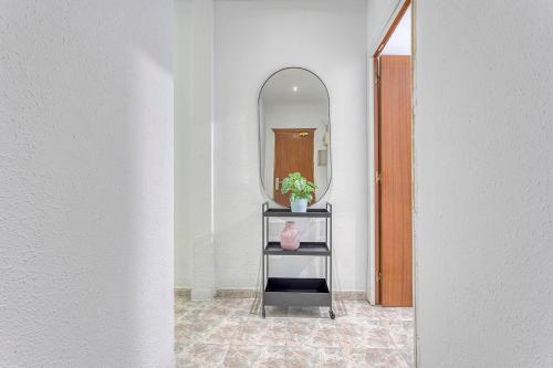 a hallway with a mirror and a shelf with a potted plant at HOSTAL BEDMATES in Barcelona