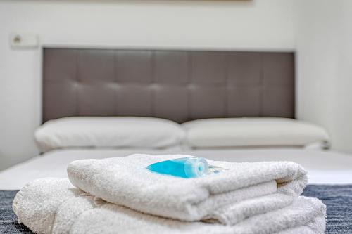 a pile of towels sitting on top of a bed at HOSTAL BEDMATES in Barcelona