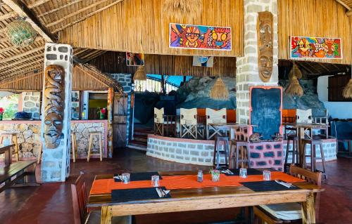 un ristorante con un grande tavolo in legno in una stanza di Tamarin Lodge ad Ampangorinana