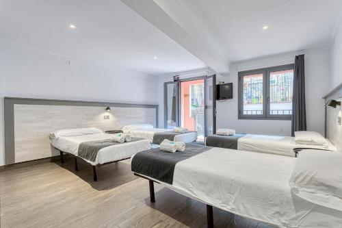 a room with three beds and a flat screen tv at HOSTAL BEDMATES in Barcelona