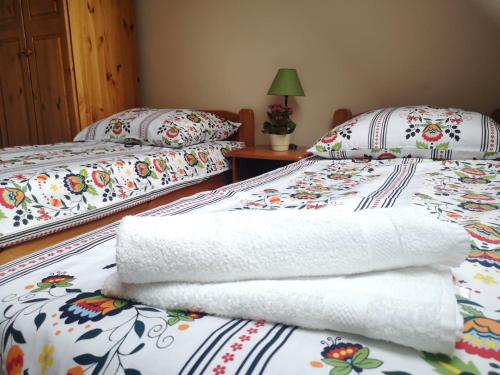 two beds with towels on them in a room at noclegi KALMA in Ostróda