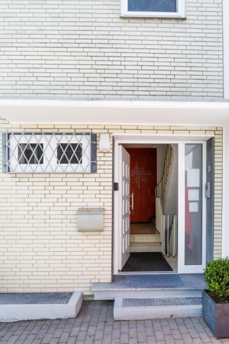 a brick building with a red door and stairs at Ferienwohnung Morillenhang in Aachen