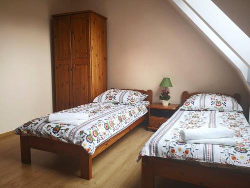 Cette chambre mansardée comprend 2 lits jumeaux. dans l'établissement noclegi KALMA, à Ostróda