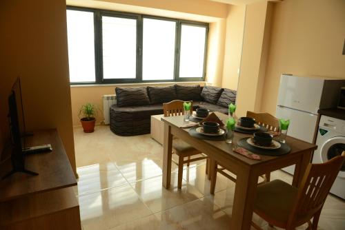 a kitchen and living room with a table and chairs at Family Hotel Gotse Delchev in Gotse Delchev