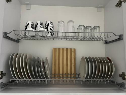 a shelf with dishes and glasses on it in a room at Spiranca Luxury Apartments in Tirana