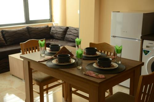 a dining room table with plates and cups on it at Family Hotel Gotse Delchev in Gotse Delchev