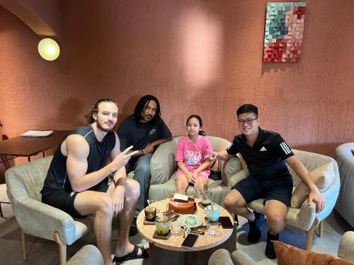 un grupo de personas sentadas en un sofá en Mon Homestay Hạ Long, en Ha Long