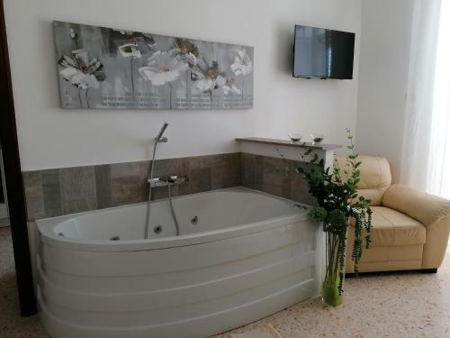 una vasca da bagno bianca in una camera con divano di Casa rosa Abruzzo 3 a Musellaro