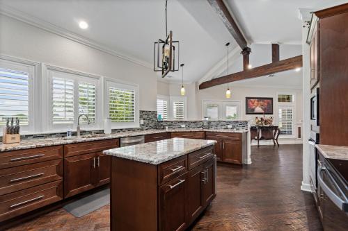 a large kitchen with wooden cabinets and granite counter tops at Newly Renovated Private Ranch Get-A-Way in Pilot Point