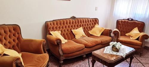 a living room with two leather couches and a table at REST HOUSE Casa familiar - garage - TV - WiFi - 2 dormitorios - Living-comedor - Cocina - Lavadero - Patio con parrilla - Alquiler temporario in Concepción del Uruguay