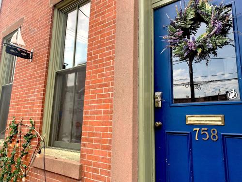 a blue door on a brick building with a wreath on it at The Philadelphia Hotel Bella Vista in Philadelphia