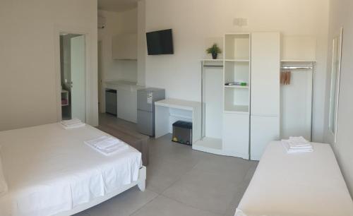a white room with two beds and a kitchen at Ritò in Gallipoli