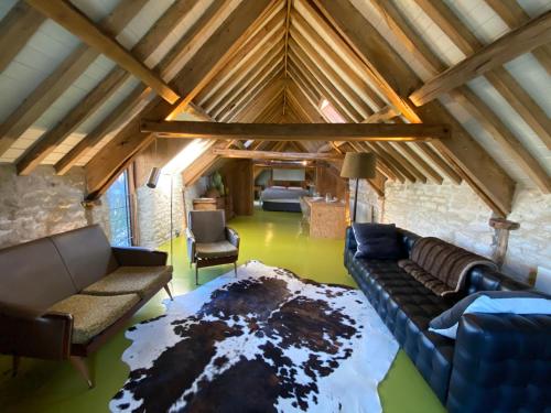 a living room with a couch and chairs in a attic at The Hayloft in Stonehouse