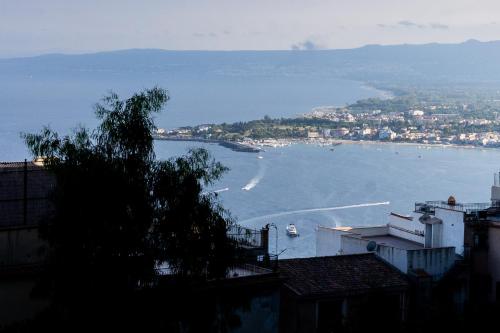 uma vista para uma baía com um barco na água em Tyche apartaments & rooms em Taormina