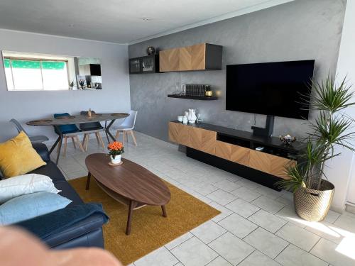 a living room with a blue couch and a flat screen tv at La Goélette ou Souléou front de mer 3étoiles appartement 2 chambres in Toulon