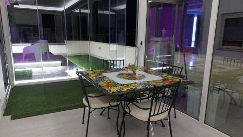 a table and chairs in a room with a window at Attico Sottovento in Reggio Calabria