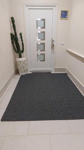 a hallway with a black rug in front of a door at Attico Sottovento in Reggio Calabria