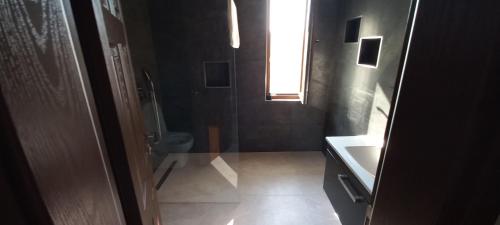 een badkamer met een toilet, een wastafel en een raam bij Ölüdeniz Özel yüzme havuzlu villa 2 in Fethiye