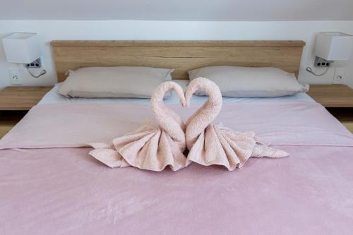 zwei Handtuch-Schwäne, die ein Herz auf einem Bett bilden in der Unterkunft Apartmani Tomšić in Darda