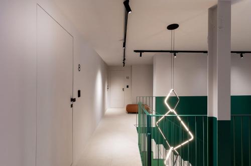 un pasillo con paredes blancas y una pared verde y blanca en Elide Design Hotel, en Asís