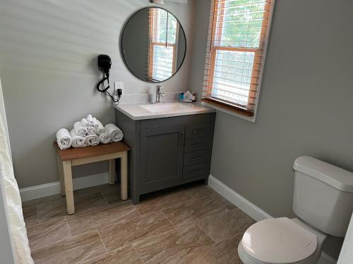 a bathroom with a sink and a toilet and a mirror at Captains Quarters Motel & Conference Center in Eastham