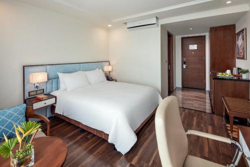 a bedroom with a large bed and a living room at Ravatel Luxury Hotel Bac Giang in Bắc Giang