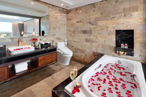 a bathroom with a tub filled with red roses at Ravatel Luxury Hotel Bac Giang in Bắc Giang